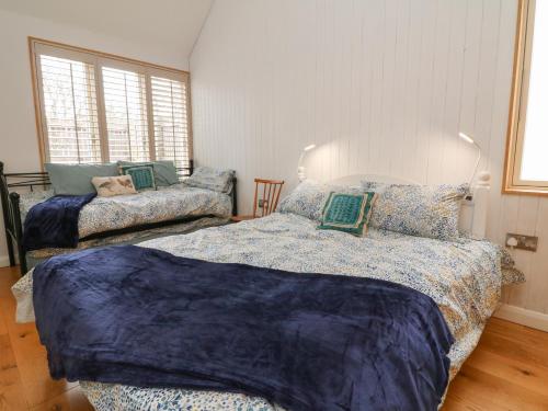 a bedroom with two beds with blue sheets on them at The Beehive in Exeter