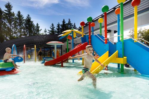 a young boy playing in the water at a water park at Collins Beach in Ustronie Morskie