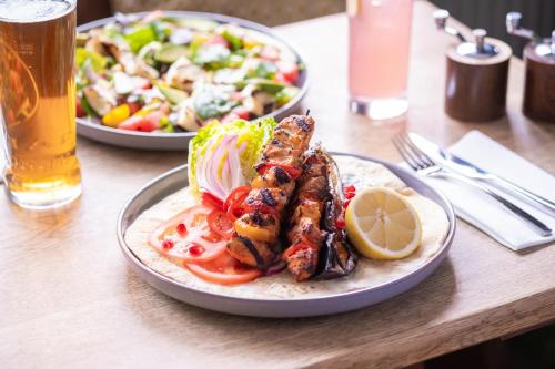 a table with two plates of food and a salad at White Hart Inn in Blythburgh