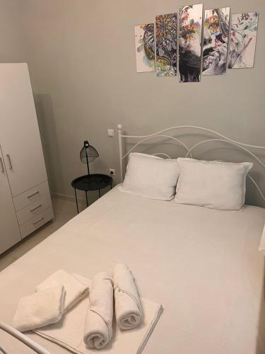 a white bed with two towels on top of it at Christina Apartments in Keramoti