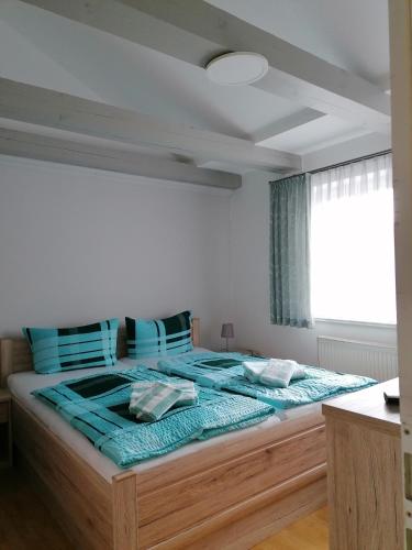 a bedroom with a large bed with blue sheets and a window at Ferienwohnung Neuer Weg 15 in Quedlinburg