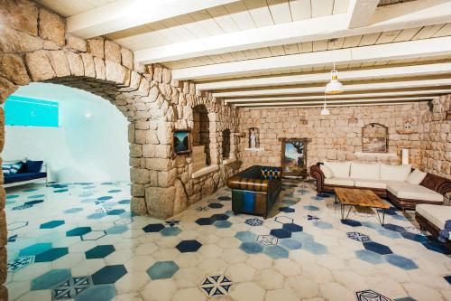 a living room with a stone wall with a couch and tables at VILLA G., Relaxing and Unique nest of Enjoyment in Imotski