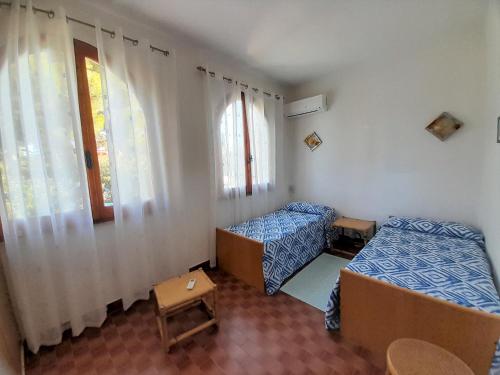 a room with two beds and a window at Nuova Valmar Villa Carta 100 mt mare in Costa Rei