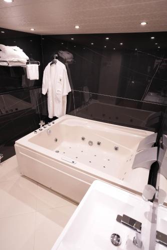 a bath tub with a shirt hanging on a wall at Layali Al Shams Hotel in ‘Anjar