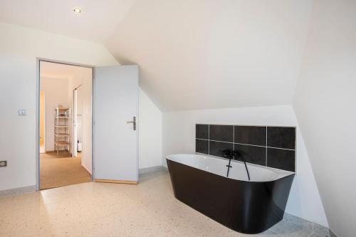 a bathroom with a black tub in a room at Villa des Vergers in Cornihout-du-Mesnil