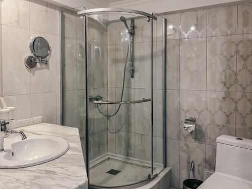 a bathroom with a shower and a sink at Shiny River Hotel in Ustʼ-Kamenogorsk