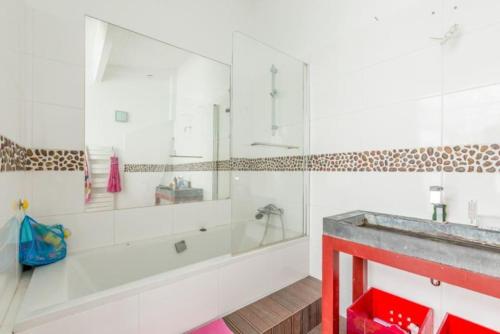 ein Badezimmer mit einer Badewanne und einem Waschbecken in der Unterkunft Appartement de 3 chambres avec spa terrasse amenagee et wifi a Colombes in Colombes