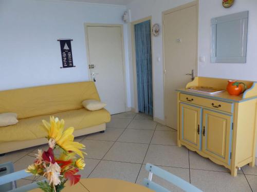 un salon avec un canapé jaune et une table dans l'établissement Studio au bord de l'eau avec parking privé et WiFi - FR-1-308-64, au Lavandou