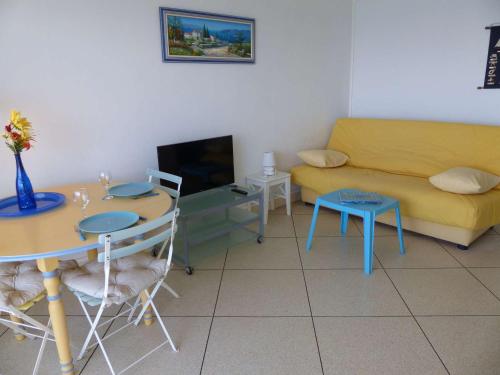 un salon avec une table et un canapé dans l'établissement Studio au bord de l'eau avec parking privé et WiFi - FR-1-308-64, au Lavandou
