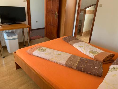 2 camas en una habitación con TV y una habitación con en Hableány Étterem, Pizzéria és Vendégház, en Balatonmáriafürdő
