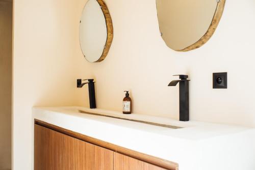 een badkamer met een wastafel en 2 spiegels bij Villa Alemagou in La Croix-Valmer