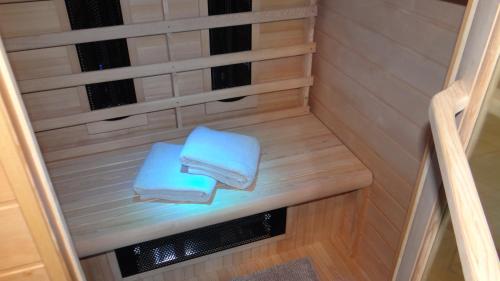 2 serviettes assises sur un banc dans un sauna dans l'établissement Bungalow aan de Visbeekvallei, à Vlimmeren