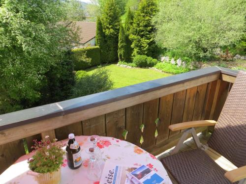 a table on a balcony with a view of a garden at Pension Marianne - Chiemgau Karte in Inzell