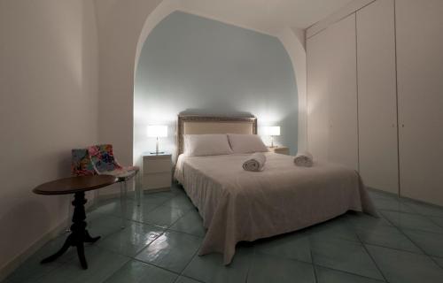 1 dormitorio con 1 cama, 1 mesa y 2 lámparas en Amalfi Coast Boutique apartment -sea view - AQUAMARINA, en Minori