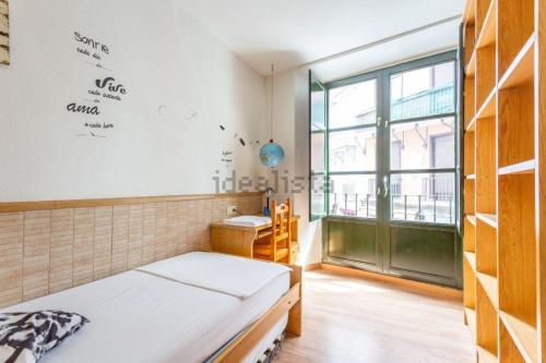 Trampantojo Apartamento en el Corazon de Pamplona في بامبلونا: غرفة نوم بسرير ومكتب ونافذة