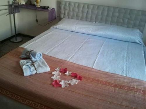 a bed with white sheets and pink flowers on it at Al Relax in Cagliari