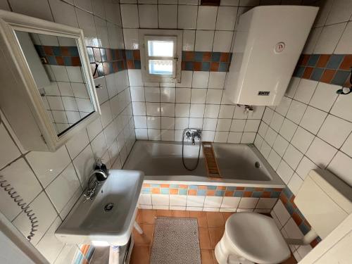 a bathroom with a tub and a sink and a toilet at Weingarten Lodge in Winten