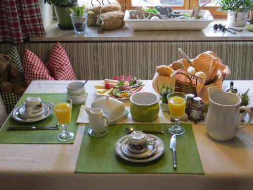a table topped with plates and glasses of orange juice at Pension Marianne - Chiemgau Karte in Inzell