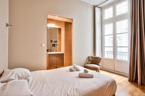 une chambre avec un lit, une chaise et une fenêtre dans l'établissement En plein centre ville appartement d'exception, à Nantes