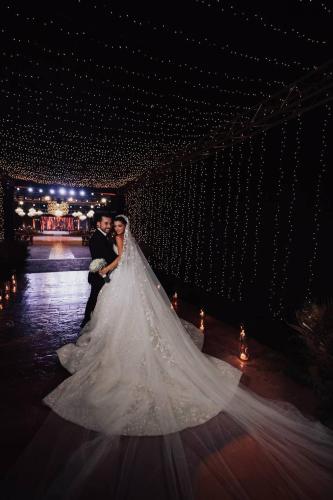 a bride and groom posing for a picture in a wedding dress at Layali Al Shams Hotel in ‘Anjar
