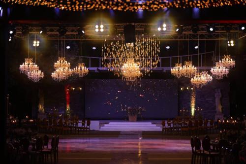 a room with chandeliers and a stage with chairs at Layali Al Shams Hotel in ‘Anjar