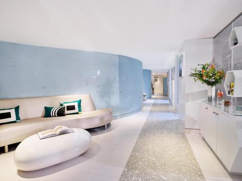 uma sala de estar com um sofá e um repousa-pés em Le Meurice – Dorchester Collection em Paris