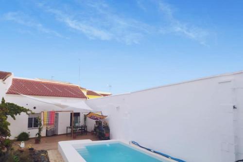 una casa blanca con piscina frente a ella en Casa con piscina cerca de Sevilla, en Carrión de los Céspedes