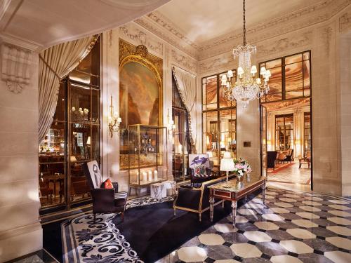 a room with a chandelier and a living room at Le Meurice – Dorchester Collection in Paris