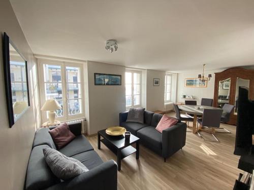 a living room with two couches and a table at Appartement Les Corsaires in Granville