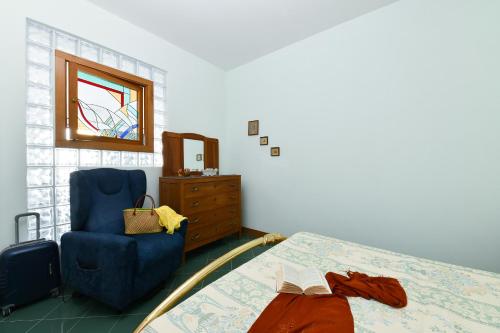een slaapkamer met een bed, een stoel en een raam bij La casa del Conte - Amalfi Coast in Amalfi