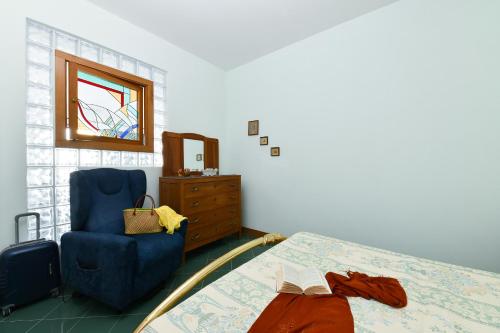a bedroom with a bed and a chair and a window at La casa del Conte - Amalfi Coast in Amalfi