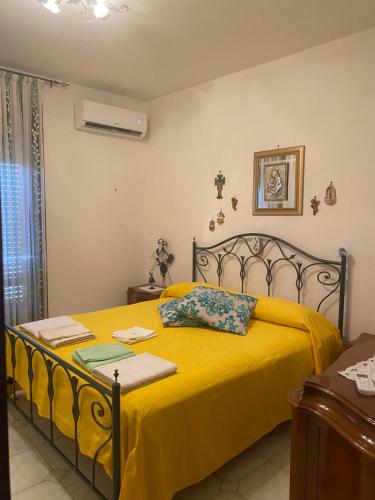 sypialnia z łóżkiem z żółtym kocem w obiekcie Appartamento Adriana w mieście Trecase