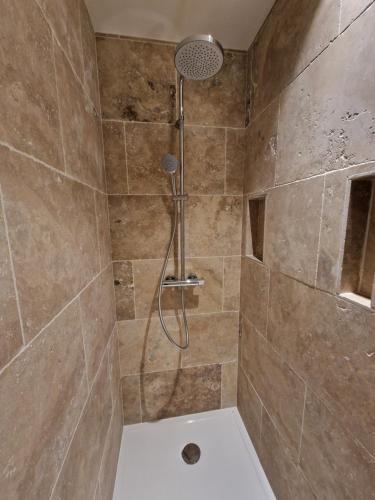 une douche avec pommeau de douche dans une salle de bain dans l'établissement Les Papillons du Ventoux - L'Aurore de Provence - twee slaapkamerappartement met terras en tuin, à Malaucène