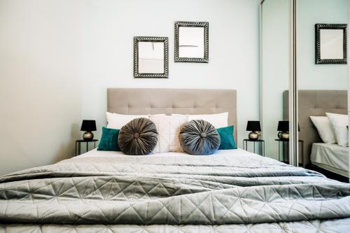 a bedroom with a large bed with blue pillows at Melos House - Charming Apartment with Jacuzzi in the Heart of the City Perfect for Memorable Summer Experiences By Villa Mana Gers in Zakynthos Town