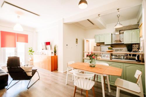 a kitchen and living room with a table and chairs at Melos House - Charming Apartment with Jacuzzi in the Heart of the City Perfect for Memorable Summer Experiences By Villa Mana Gers in Zakynthos Town