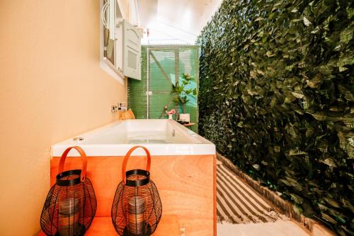 a bathroom with a sink and a green wall at Melos House - Charming Apartment with Jacuzzi in the Heart of the City Perfect for Memorable Summer Experiences By Villa Mana Gers in Zakynthos Town