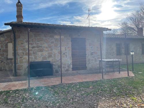 a stone house with a screened in porch with a table at Agriturismo Eco-Bio Villa Vacasio in Pitigliano