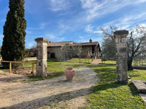 a house with two stone pillars in the yard at Agriturismo Eco-Bio Villa Vacasio in Pitigliano