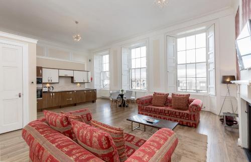 エディンバラにあるYork Place Apartments by Destination Edinburghのリビングルーム(ソファ2台付)、キッチンが備わります。
