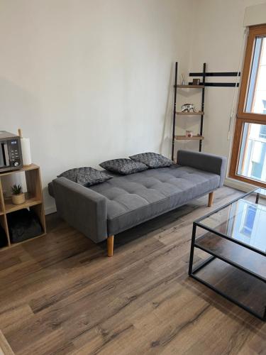a living room with a couch and a glass table at Appartement 2 pièces ligne 1 in Montreuil