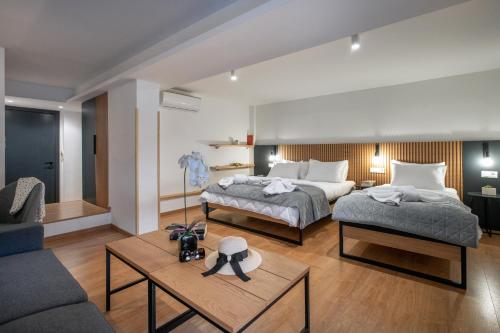 a bedroom with two beds and a living room at Traveleclectic Apartments in Corfu