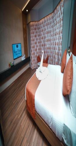 a hotel room with a bed and a tv at Grand Palace Hotel & Spa in Yercaud