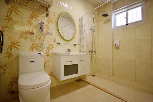 a bathroom with a toilet and a shower and a sink at GJia Taitung B&B in Taitung City