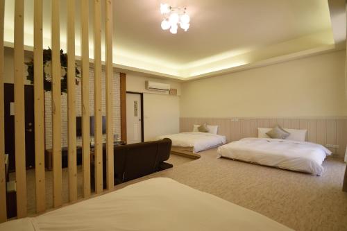 a hotel room with two beds and a couch at GJia Taitung B&B in Taitung City