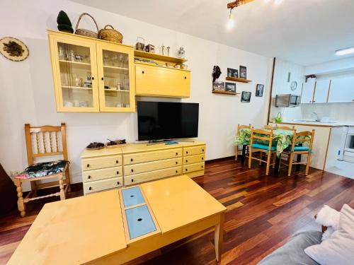 a living room with a tv and a table at El refugio de la ardilla, apartamento Canfranc-estacion in Canfranc-Estación