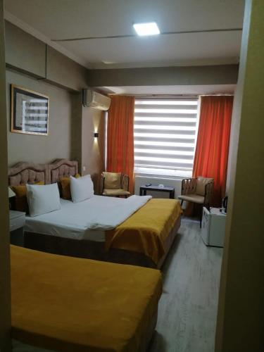 a hotel room with two beds and a window at Masal Otel in Kocaeli