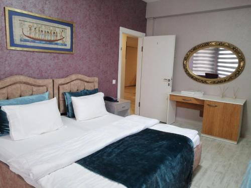 a bedroom with a large bed and a mirror at Masal Otel in Kocaeli