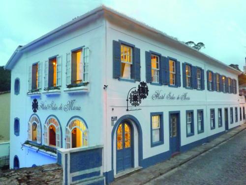 um edifício azul e branco com janelas numa rua em Hotel Solar de Maria em Ouro Preto