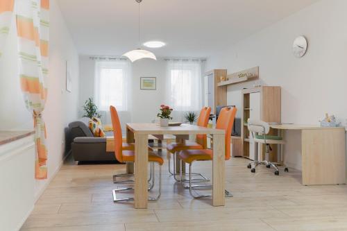 una sala da pranzo con tavolo e sedie arancioni di Pri Neji a Postumia