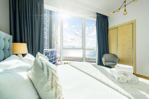 a bedroom with a bed and a large window at LUX The JBR Beach Sea View Suite in Dubai
